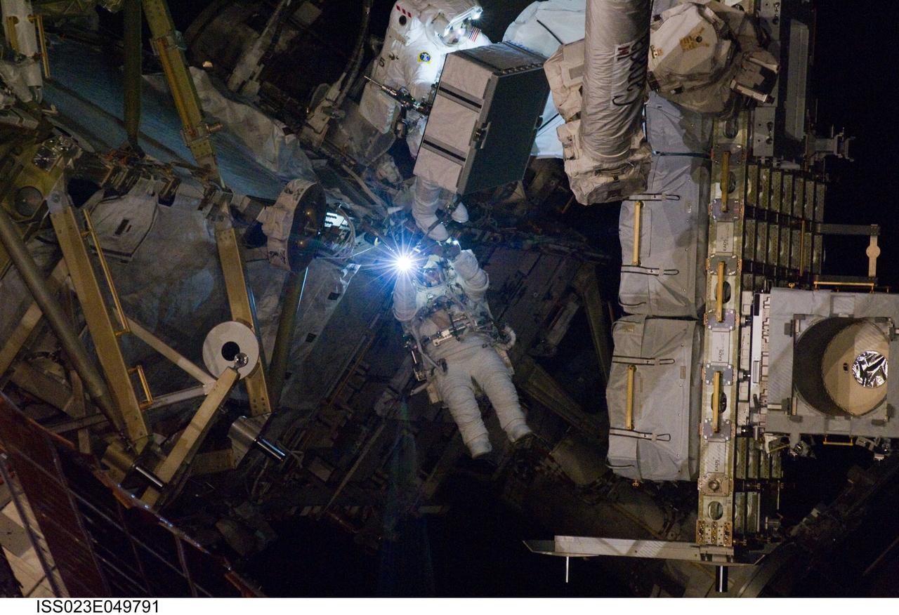 ISS023-E-049791 (21 May 2010) --- NASA astronauts Garrett Reisman (bottom) and Michael Good, both STS-132 mission specialists, participate in the mission?s third and final session of extravehicular activity (EVA) as construction and maintenance continue on the International Space Station. During the six-hour, 46-minute spacewalk, Reisman and Good completed the installation of the final two of the six new batteries for the B side of the port 6 solar array. In addition, the astronauts installed a backup ammonia jumper cable between the port 4 and 5 trusses of the station, transferred a Power and Data Grapple Fixture from the shuttle to the station, and reconfigured some tools.