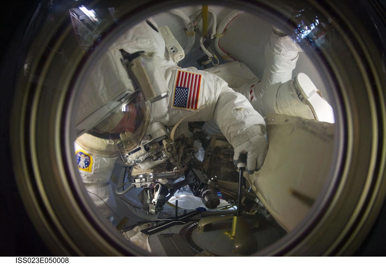 ISS023-E-050008 (21 May 2010) --- NASA astronauts Garrett Reisman and Michael Good, both STS-132 mission specialists, enter the Quest airlock of the International Space Station as the mission?s third and final session of extravehicular activity (EVA) draws to a close.
