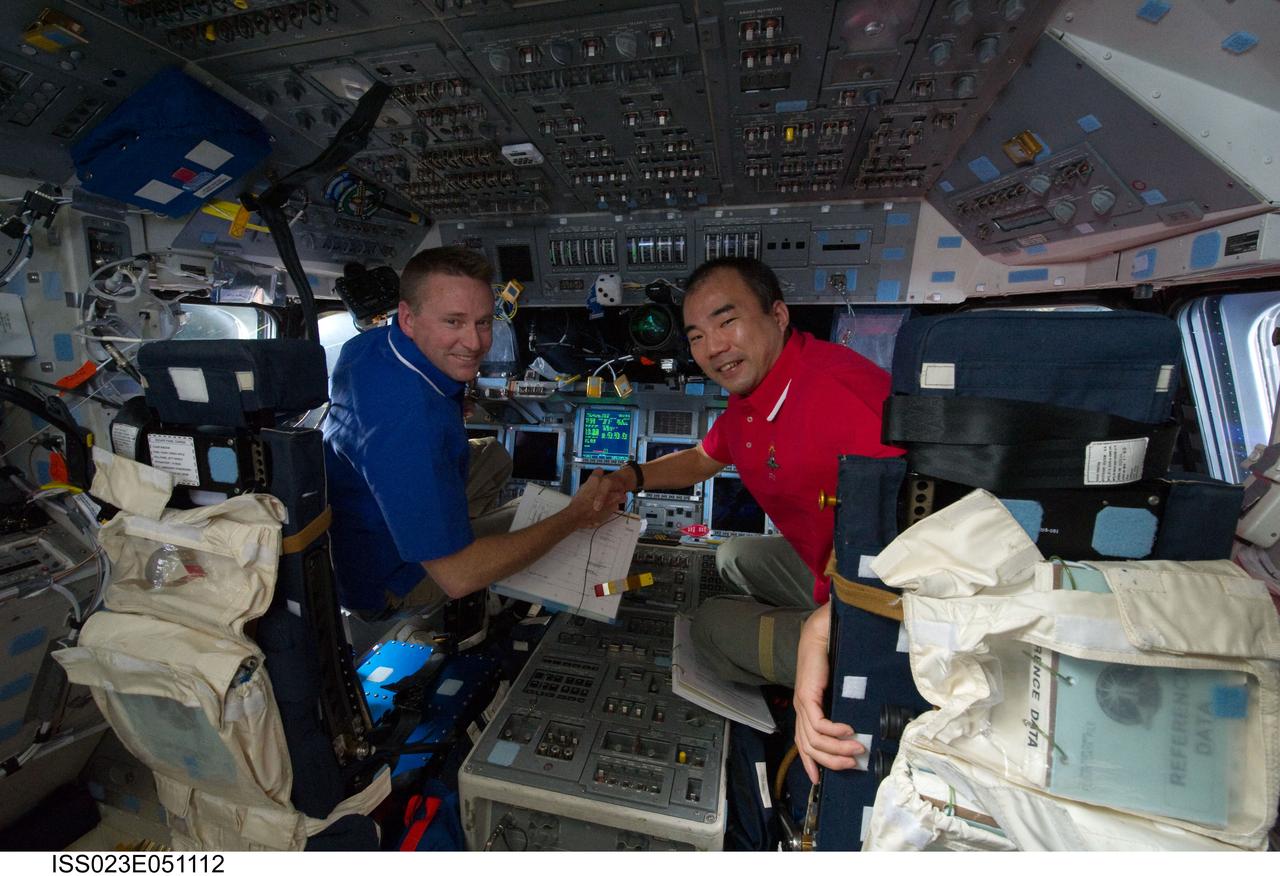 ISS023-E-051112 (23 May 2010) --- NASA astronaut Ken Ham (left), STS-132 commander; and Japan Aerospace Exploration Agency (JAXA) astronaut Soichi Noguchi, Expedition 23 flight engineer, are pictured on the forward flight deck of space shuttle Atlantis while docked with the International Space Station.