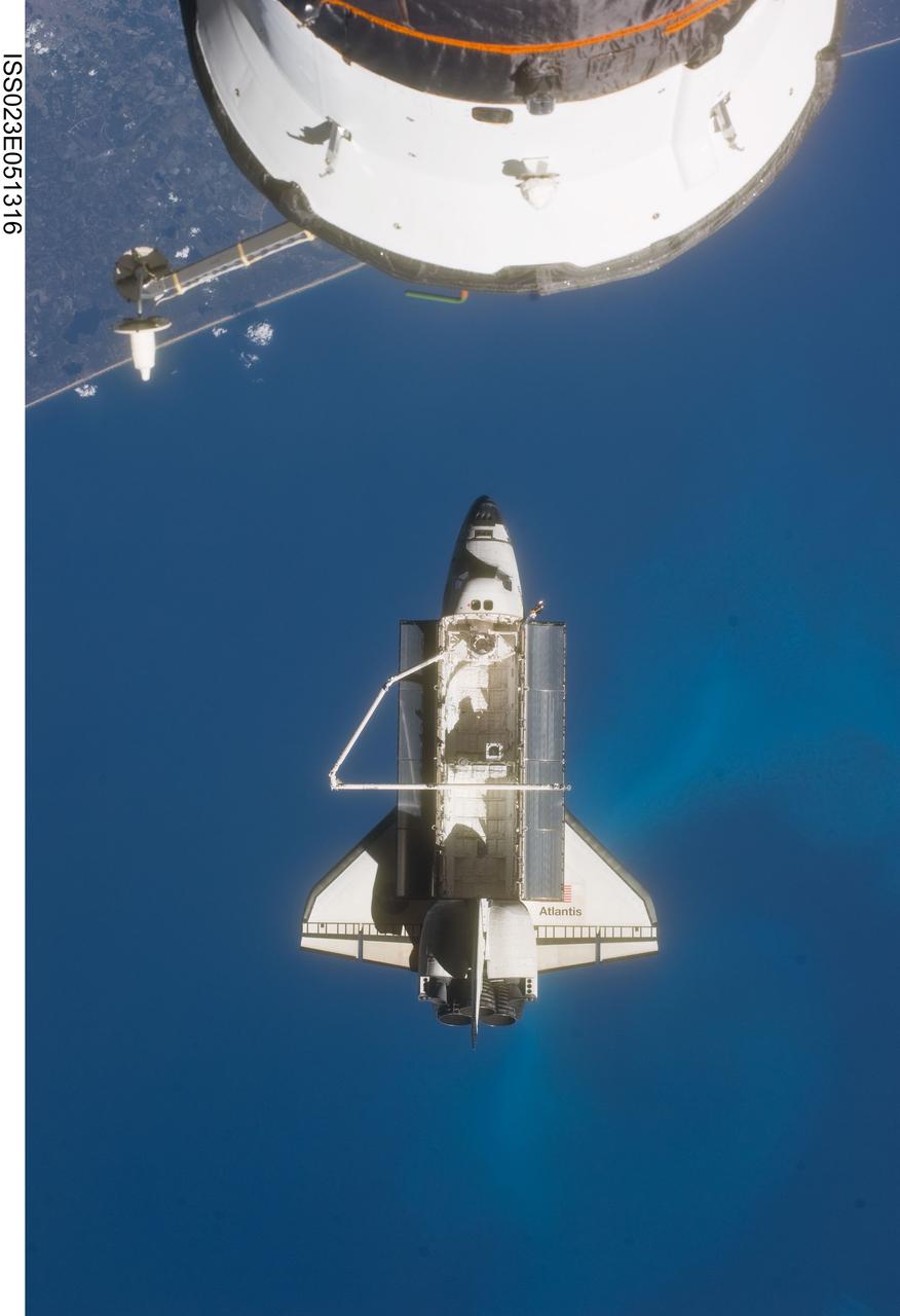 ISS023-E-051316 (23 May 2010) --- Space shuttle Atlantis is featured in this image photographed by an Expedition 23 crew member on the International Space Station soon after the shuttle and station began their post-undocking relative separation. Undocking of the two spacecraft occurred at 10:22 a.m. (CDT) on May 23, 2010, ending a seven-day stay that saw the addition of a new station module, replacement of batteries and resupply of the orbiting outpost. A portion of a Russian spacecraft docked to the station is at top. A blue part of Earth provides the backdrop for the scene.