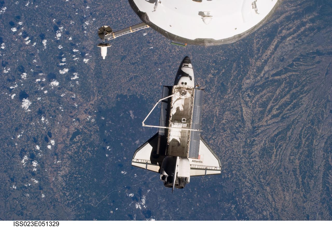 ISS023-E-051329 (23 May 2010) --- Space shuttle Atlantis is featured in this image photographed by an Expedition 23 crew member on the International Space Station soon after the shuttle and station began their post-undocking relative separation. Undocking of the two spacecraft occurred at 10:22 a.m. (CDT) on May 23, 2010, ending a seven-day stay that saw the addition of a new station module, replacement of batteries and resupply of the orbiting outpost. A portion of a Russian spacecraft docked to the station is at top.