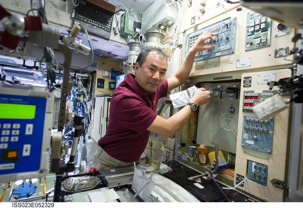 ISS023-E-052329 (26 May 2010) --- Japan Aerospace Exploration Agency (JAXA) astronaut Soichi Noguchi, Expedition 23 flight engineer, adds potable water to a soft beverage container at the galley in the Zvezda Service Module of the International Space Station.