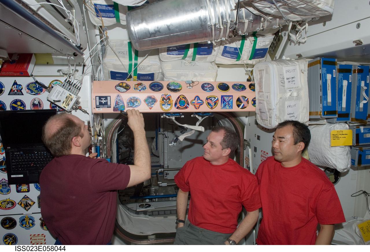 ISS023-E-058044 (1 June 2010) --- Russian cosmonaut Oleg Kotov (left), Expedition 23 commander, adds the Expedition 23 patch to the Unity node’s growing collection of insignias representing crews who have lived and worked on the International Space Station. Also pictured are NASA astronaut T.J. Creamer (center) and Japan Aerospace Exploration Agency (JAXA) astronaut Soichi Noguchi, both flight engineers.