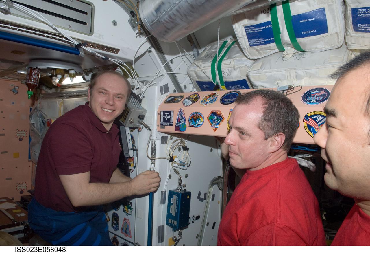 ISS023-E-058048 (1 June 2010) --- Russian cosmonaut Oleg Kotov (left), Expedition 23 commander; along with NASA astronaut T.J. Creamer (center) and Japan Aerospace Exploration Agency (JAXA) astronaut Soichi Noguchi, both flight engineers, are pictured after adding the Expedition 23 patch to the Unity node?s growing collection of insignias representing crews who have lived and worked on the International Space Station.