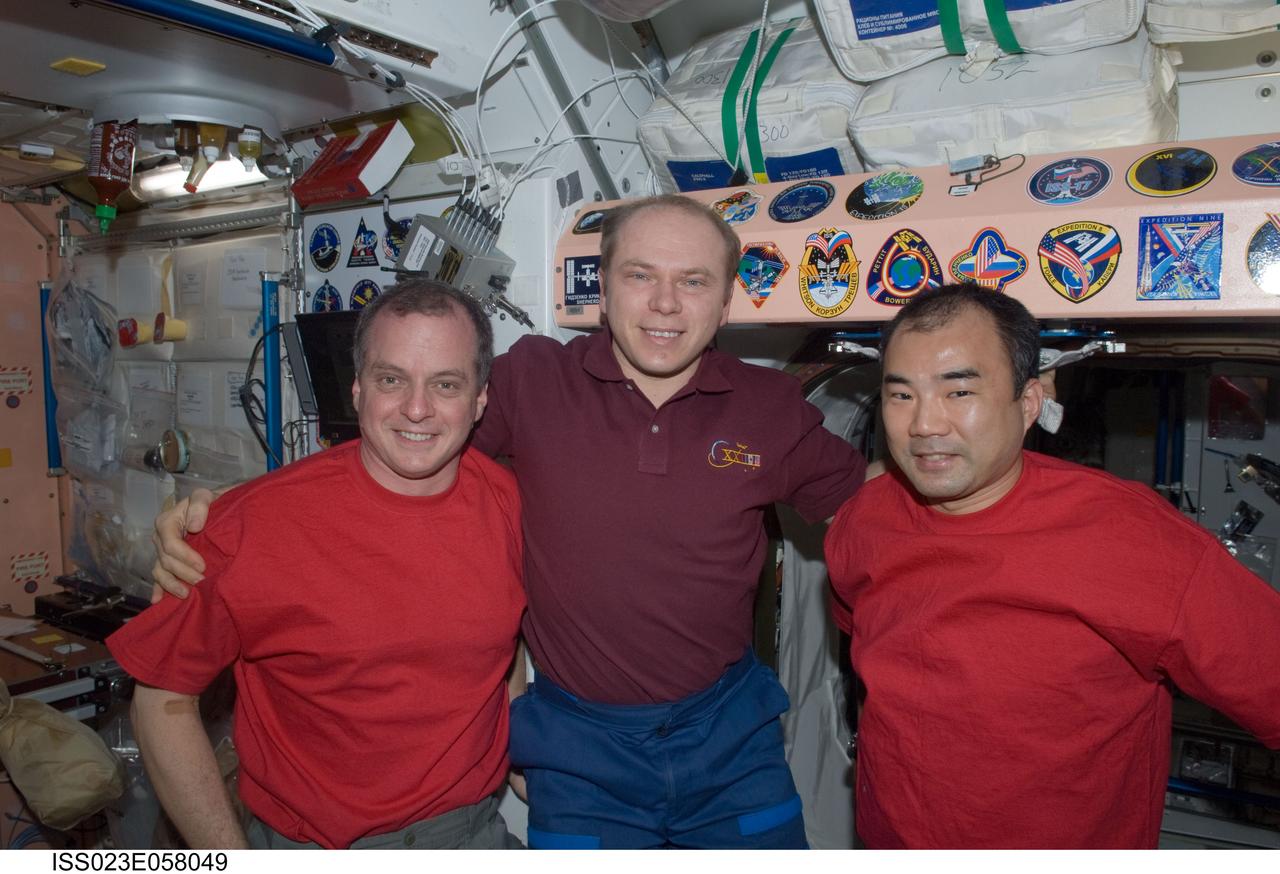 ISS023-E-058049 (1 June 2010) --- Russian cosmonaut Oleg Kotov (center), Expedition 23 commander; along with NASA astronaut T.J. Creamer (left) and Japan Aerospace Exploration Agency (JAXA) astronaut Soichi Noguchi, both flight engineers, pose for a photo after adding the Expedition 23 patch to the Unity node?s growing collection of insignias representing crews who have lived and worked on the International Space Station.