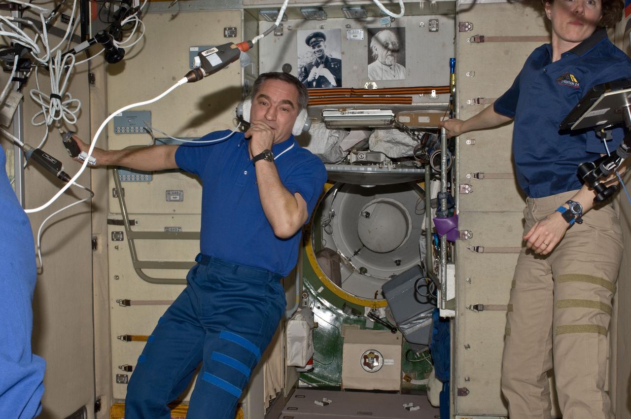 ISS024-E-006205 (17 June 2010) --- Russian cosmonaut Alexander Skvortsov, Expedition 24 commander, uses a communication system in the Zvezda Service Module of the International Space Station. NASA astronaut Tracy Caldwell Dyson, flight engineer, is at right.