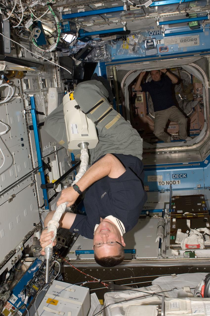 ISS024-E-006224 (20 June 2010) --- NASA astronaut Doug Wheelock, Expedition 24 flight engineer, uses a vacuum cleaner during housekeeping operations in the Destiny laboratory of the International Space Station.