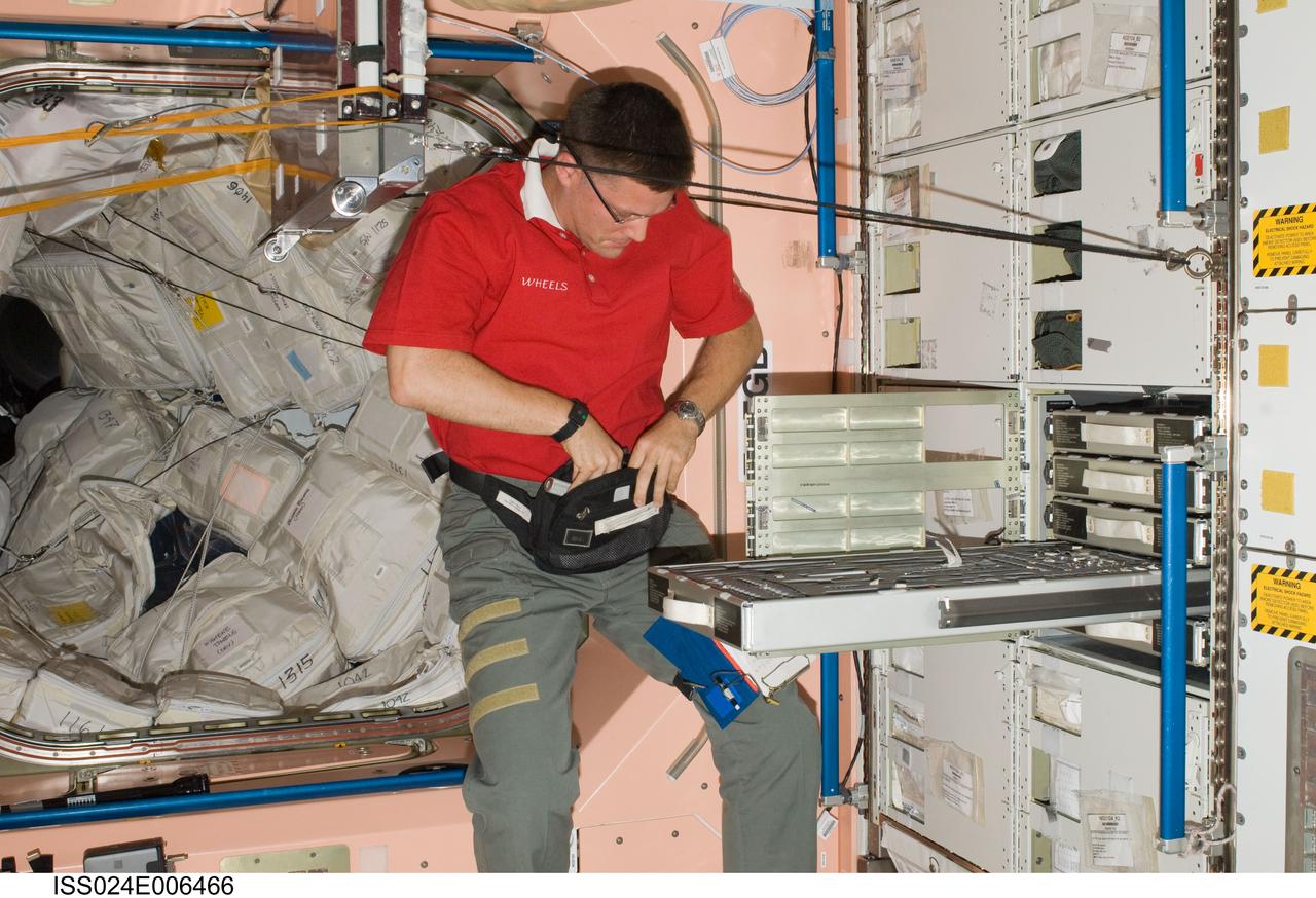 ISS024-E-006466 (24 June 2010) --- NASA astronaut Doug Wheelock, Expedition 24 flight engineer, places tools in a bag in the Unity node of the International Space Station.