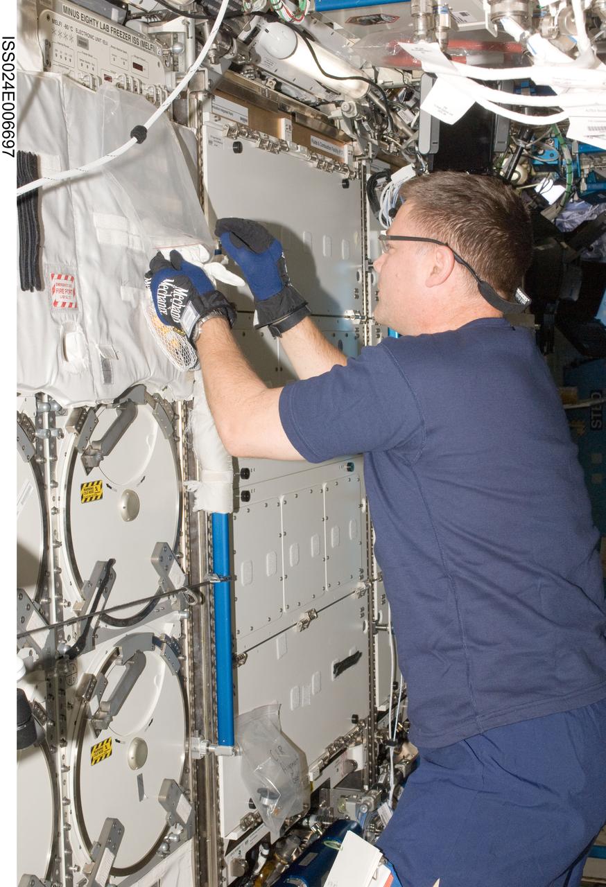 ISS024-E-006697 (28 June 2010) --- NASA astronaut Doug Wheelock, Expedition 24 flight engineer, prepares to insert biological samples into trays in the Minus Eighty Laboratory Freezer for ISS-2 (MELFI-2) in the Destiny laboratory of the International Space Station.