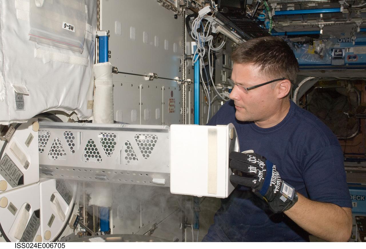 ISS024-E-006705 (28 June 2010) --- After inserting biological samples, NASA astronaut Doug Wheelock, Expedition 24 flight engineer, replaces a dewar tray in the Minus Eighty Laboratory Freezer for ISS-2 (MELFI-2) in the Destiny laboratory of the International Space Station.