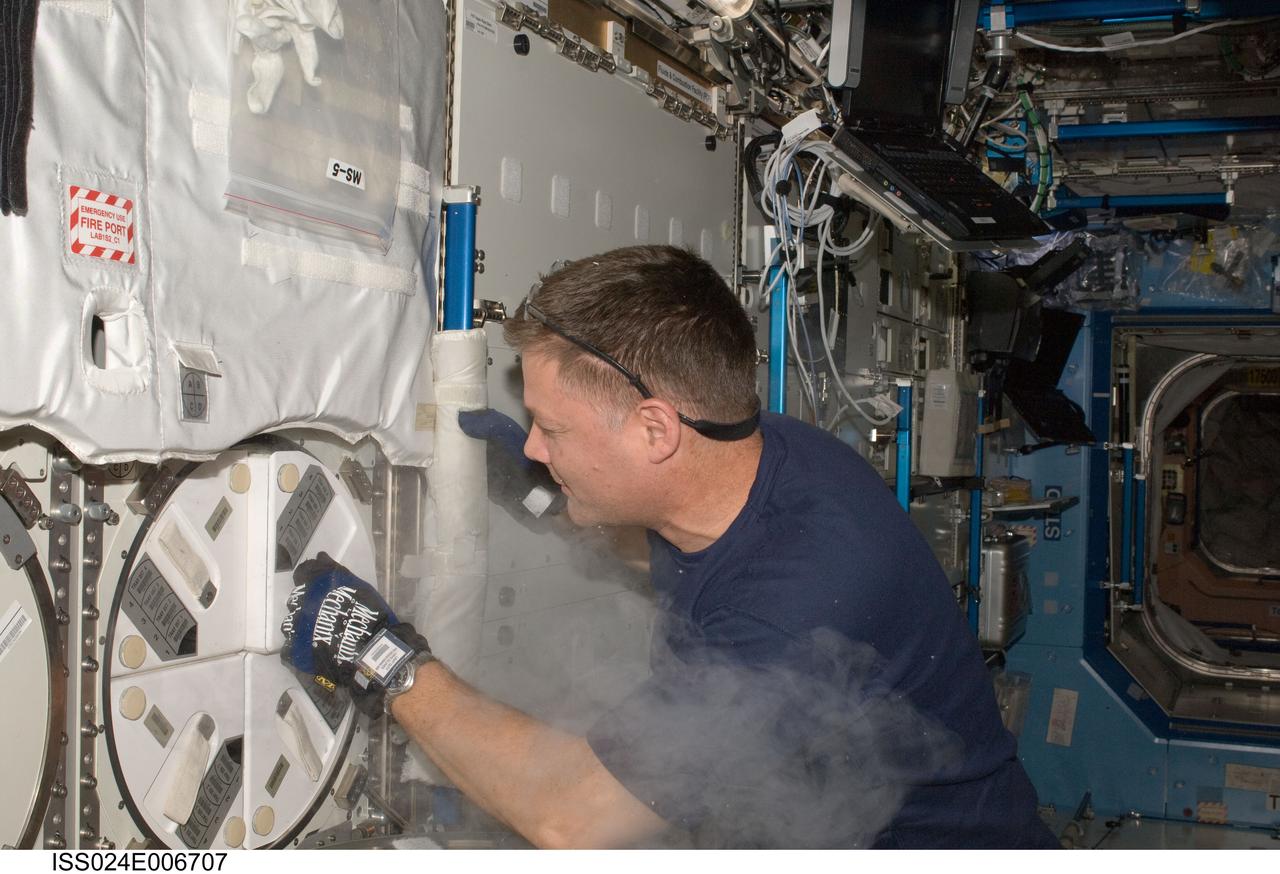 ISS024-E-006707 (28 June 2010) --- After inserting biological samples, NASA astronaut Doug Wheelock, Expedition 24 flight engineer, replaces a dewar tray in the Minus Eighty Laboratory Freezer for ISS-2 (MELFI-2) in the Destiny laboratory of the International Space Station.