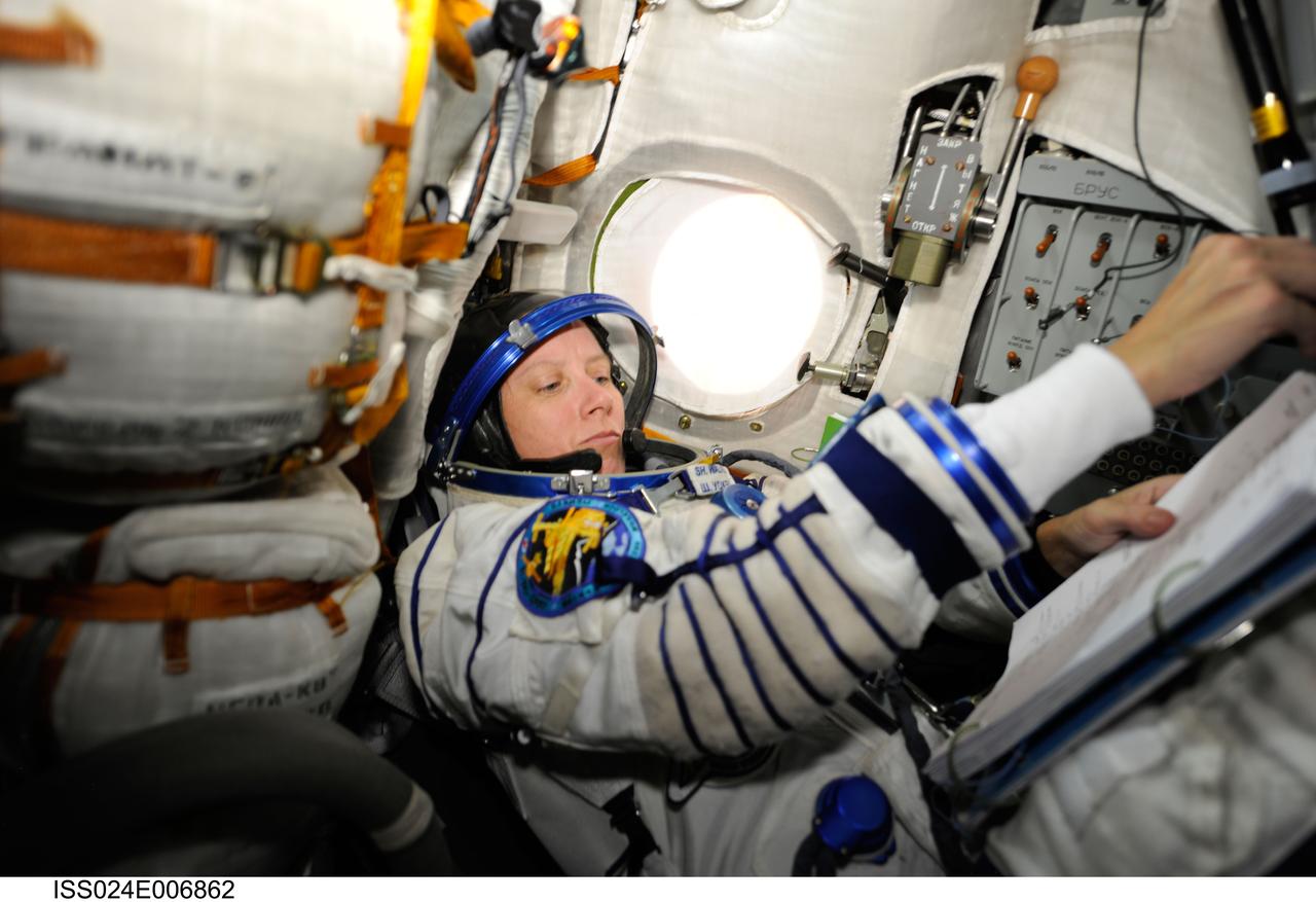 ISS024-E-006862 (28 June 2010) --- NASA astronaut Shannon Walker, Expedition 24 flight engineer, attired in her Russian Sokol launch and entry suit, occupies her seat in the Soyuz TMA-19 spacecraft docked to the International Space Station. Walker, along with Russian cosmonaut Fyodor Yurchikhin and NASA astronaut Doug Wheelock (both out of frame) were about to relocate the Soyuz from the Zvezda Service Module’s aft port to the Rassvet Mini-Research Module 1 (MRM1).
