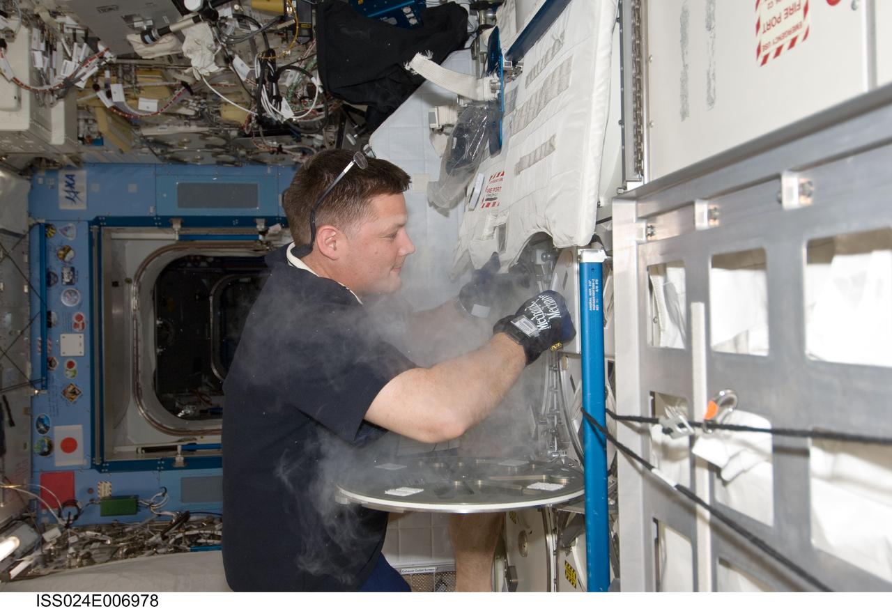 ISS024-E-006978 (27 June 2010) --- NASA astronaut Doug Wheelock, Expedition 24 flight engineer, services the Minus Eighty Laboratory Freezer for ISS (MELFI-1) in the Kibo laboratory of the International Space Station.