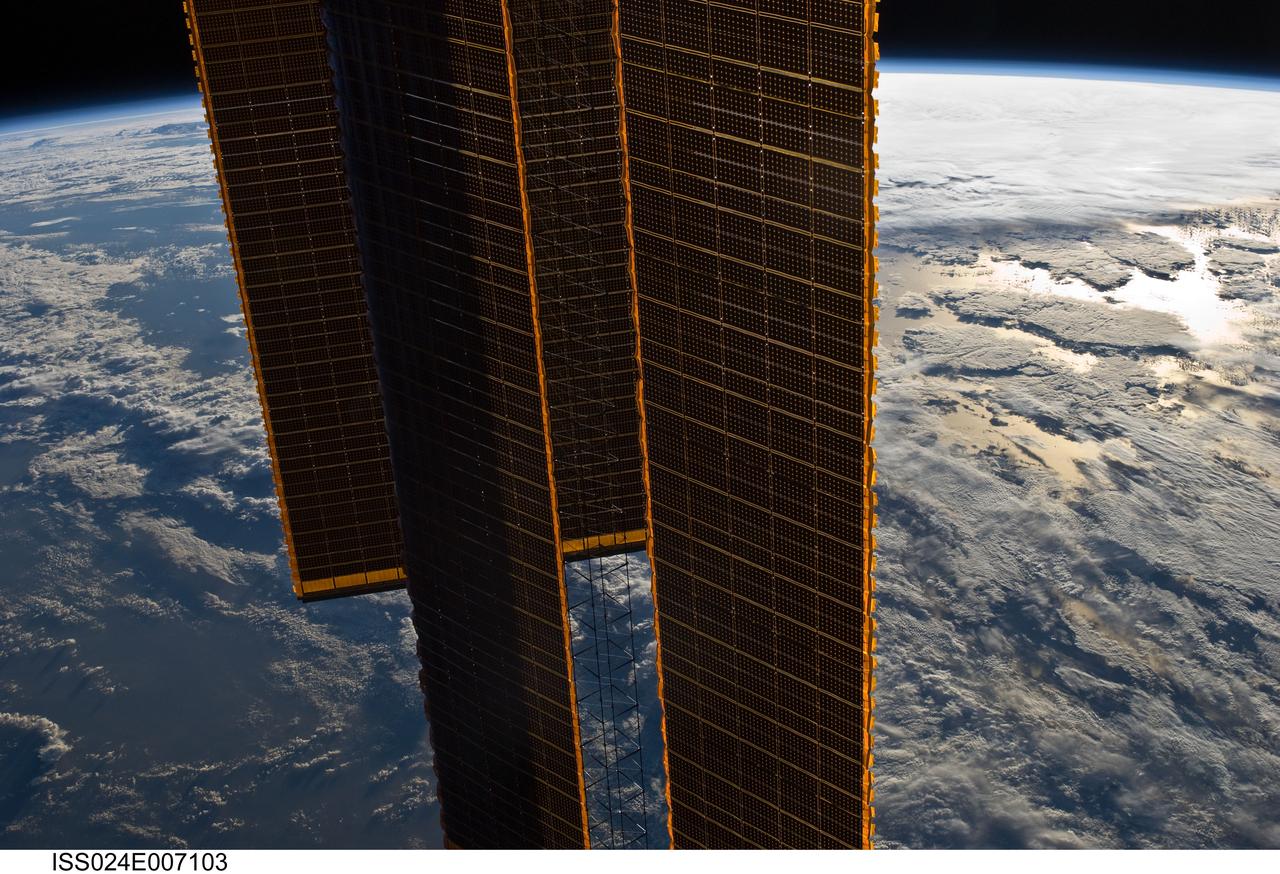 ISS024-E-007103 (29 June 2010) --- Backdropped by a blue and white part of Earth and the blackness of space, International Space Station solar array panels are featured in this image photographed by an Expedition 24 crew member aboard the station.