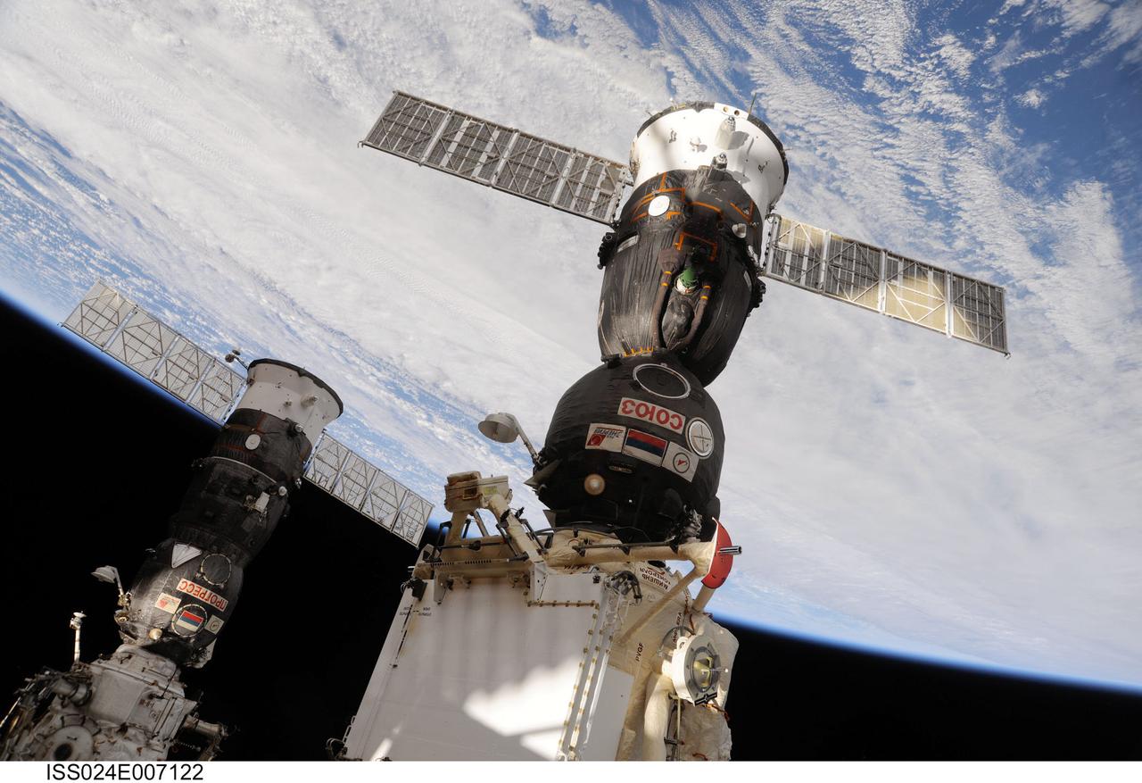 ISS024-E-007122 (30 June 2010) --- The Soyuz TMA-19 spacecraft (foreground), docked to the Rassvet Mini-Research Module 1 (MRM1), and Progress 37 resupply vehicle, docked to the Pirs Docking Compartment, are featured in this image photographed by an Expedition 24 crew member on the International Space Station. A blue and white part of Earth and the blackness of space provide the backdrop for the scene.