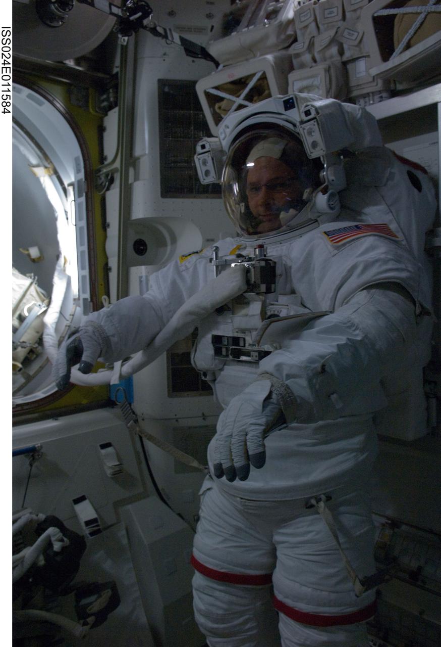 ISS024-E-011584 (7 Aug. 2010) --- NASA astronaut Doug Wheelock, Expedition 24 flight engineer, attired in his Extravehicular Mobility Unit (EMU) spacesuit, is pictured in the Quest airlock of the International Space Station prior to the start of the first of three planned spacewalks to remove and replace an ammonia pump module that failed July 31.