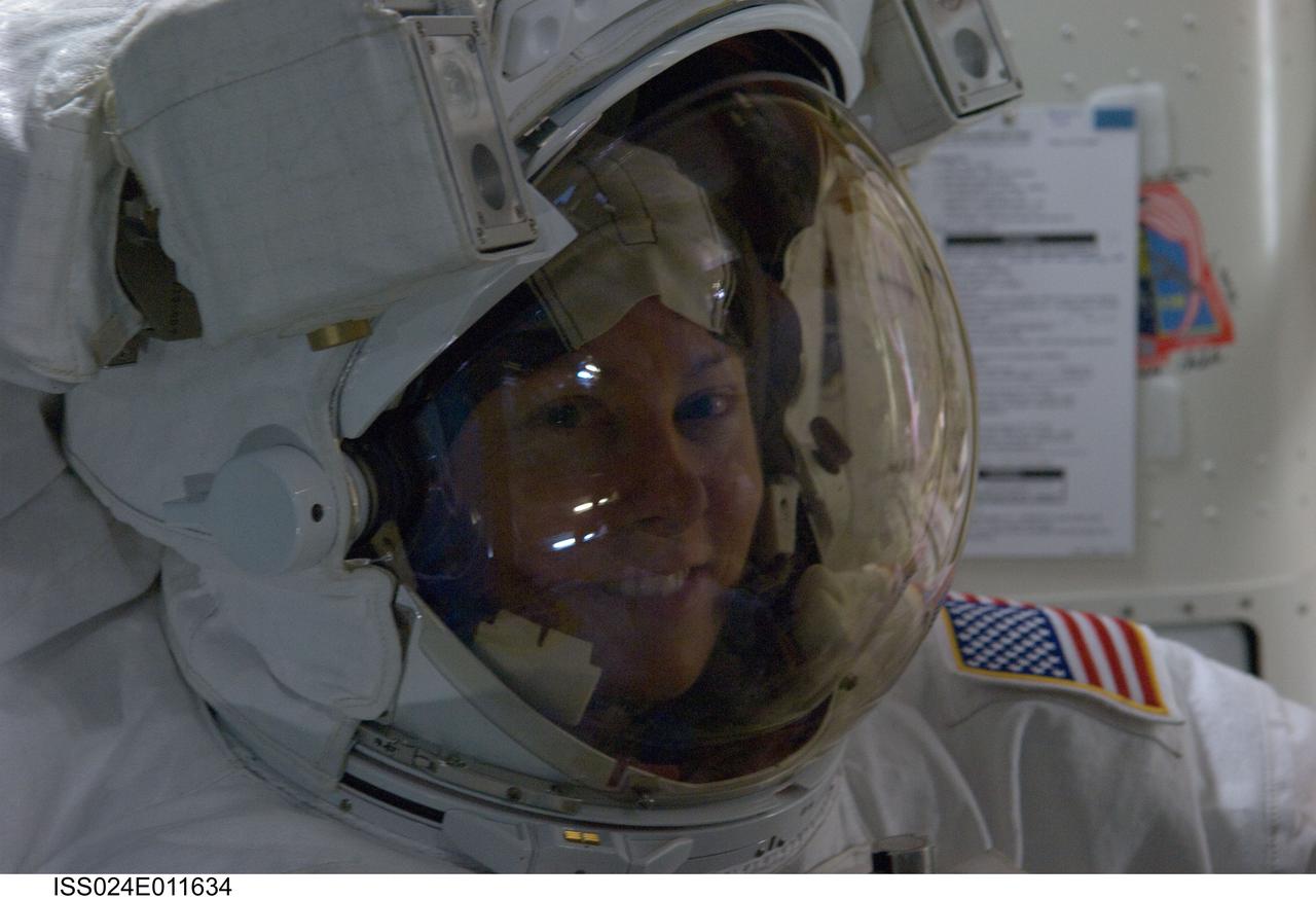 ISS024-E-011634 (7 Aug. 2010) --- Attired in her Extravehicular Mobility Unit (EMU) spacesuit, NASA astronaut Tracy Caldwell Dyson, Expedition 24 flight engineer, is pictured in the Quest airlock of the International Space Station as the first of three planned spacewalks to remove and replace an ammonia pump module that failed July 31 draws to a close.