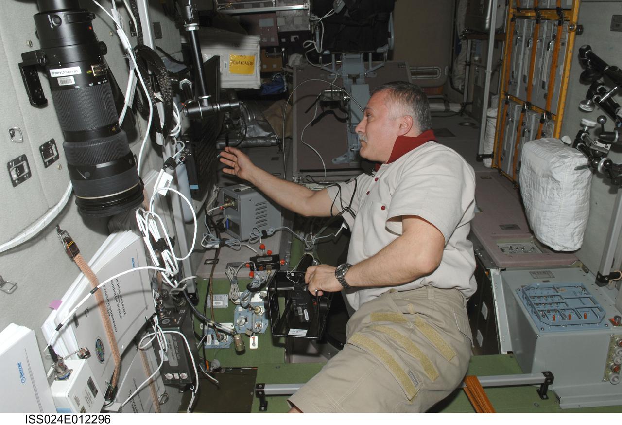 ISS024-E-012296 (19 Aug. 2010) --- Russian cosmonaut Fyodor Yurchikhin, Expedition 24 flight engineer, works with High Definition Video (HDV) camera equipment in the Zvezda Service Module of the International Space Station.