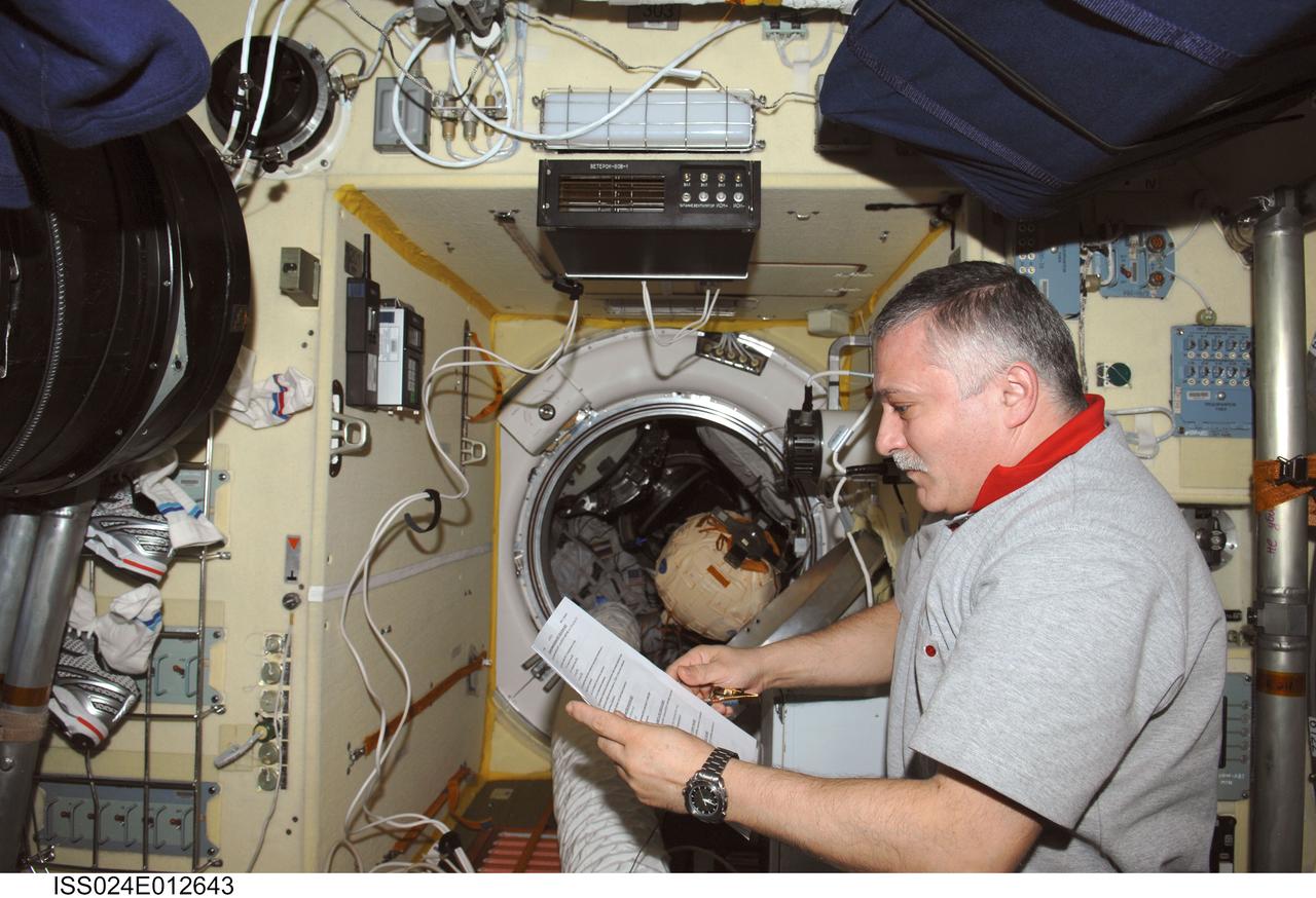 ISS024-E-012643 (27 Aug. 2010) --- Russian cosmonaut Fyodor Yurchikhin, Expedition 24 flight engineer, reads a checklist in the Poisk Mini-Research Module 2 (MRM2) of the International Space Station.