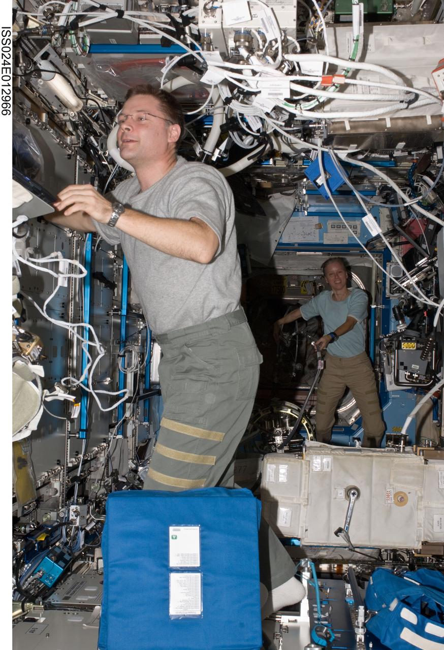ISS024-E-012966 (31 Aug. 2010) --- NASA astronauts Doug Wheelock and Shannon Walker, both Expedition 24 flight engineers, work in the Destiny laboratory of the International Space Station.