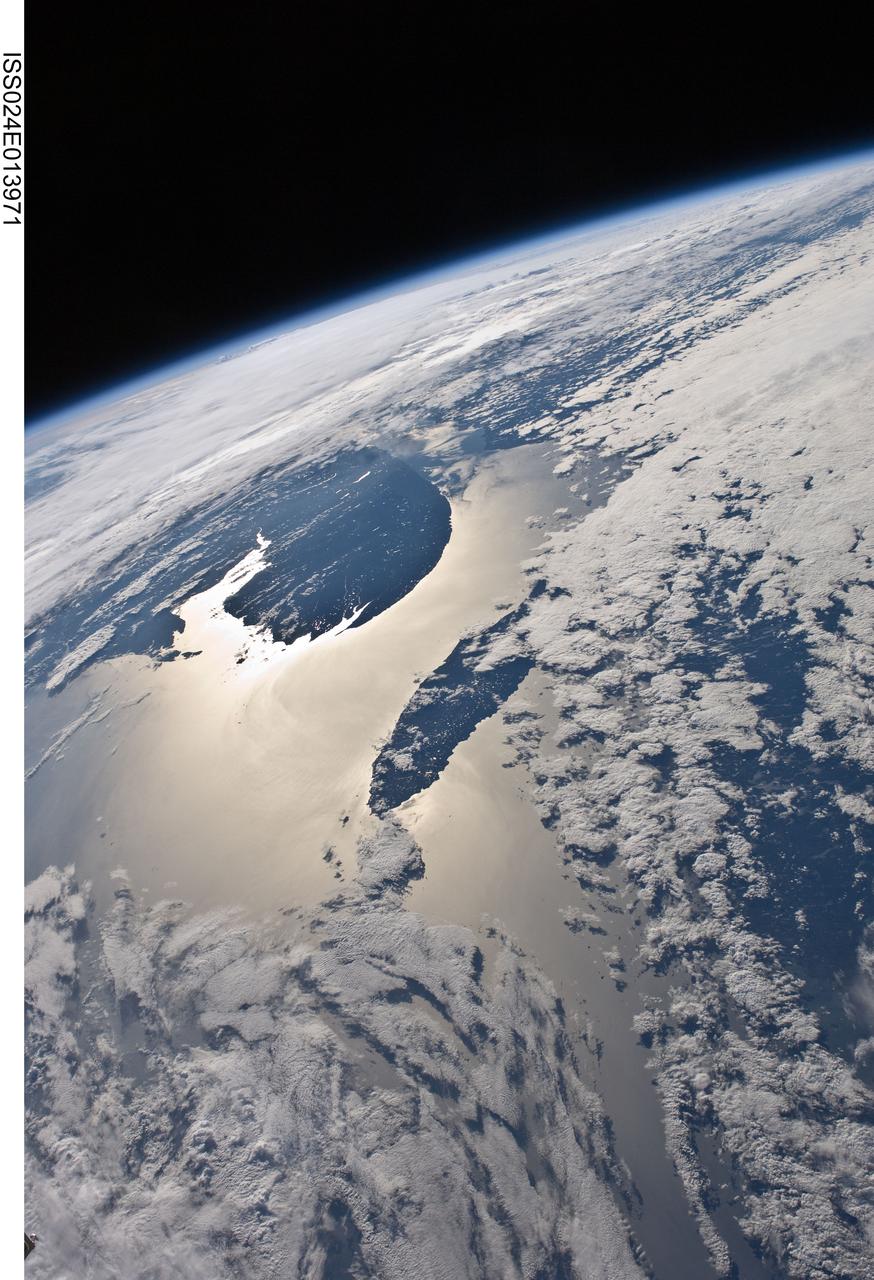 ISS024-E-013971 (7 Sept. 2010) --- This high-oblique view of the Gaspe Peninsula and Anticosti Island with sun glint on the Gulf of St. Lawrence and Chaleur Bay, Canada, was photographed by an Expedition 24 crew member on the International Space Station.