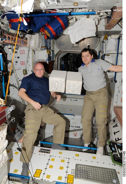ISS025-E-010146 (31 Oct. 2010) --- NASA astronaut Scott Kelly (left) and Russian cosmonaut Oleg Skripochka, both Expedition 25 flight engineers, are pictured during transfer activities of the European Space Agency?s SPHINX (SPaceflight of Huvec: an Integrated eXperiment) Biobox kit in the Unity node of the International Space Station.