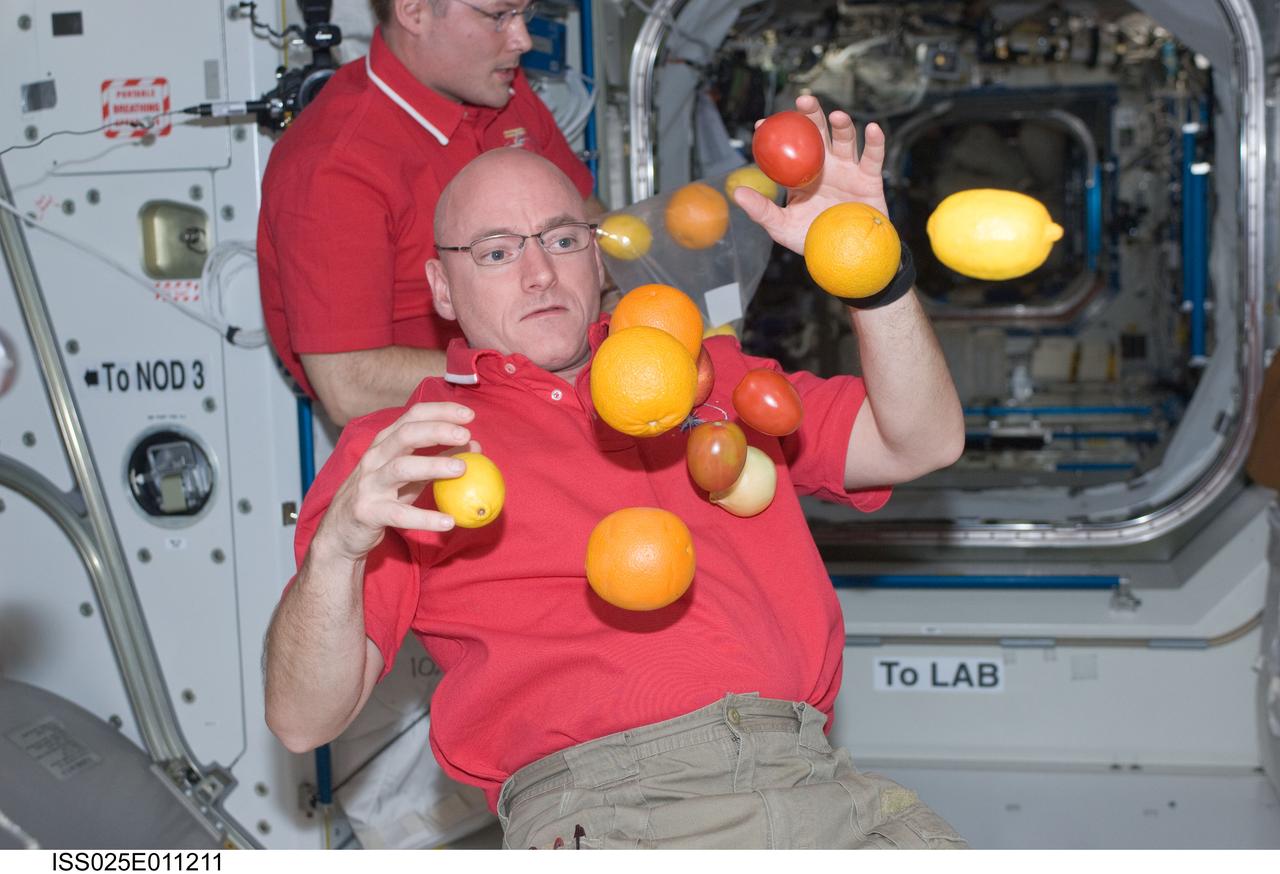 ISS025-E-011211 (3 Nov. 2010) --- NASA astronaut Scott Kelly, Expedition 25 flight engineer, is pictured near fresh fruit floating freely in the Unity node of the International Space Station. NASA astronaut Doug Wheelock, commander, is visible in the background.