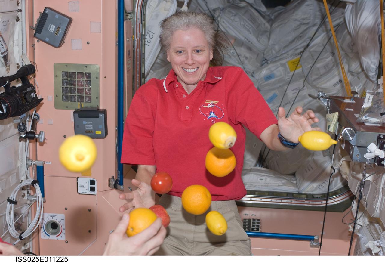 ISS025-E-011225 (3 Nov. 2010) --- NASA astronaut Shannon Walker, Expedition 25 flight engineer, is pictured near fresh fruit floating freely in the Unity node of the International Space Station.