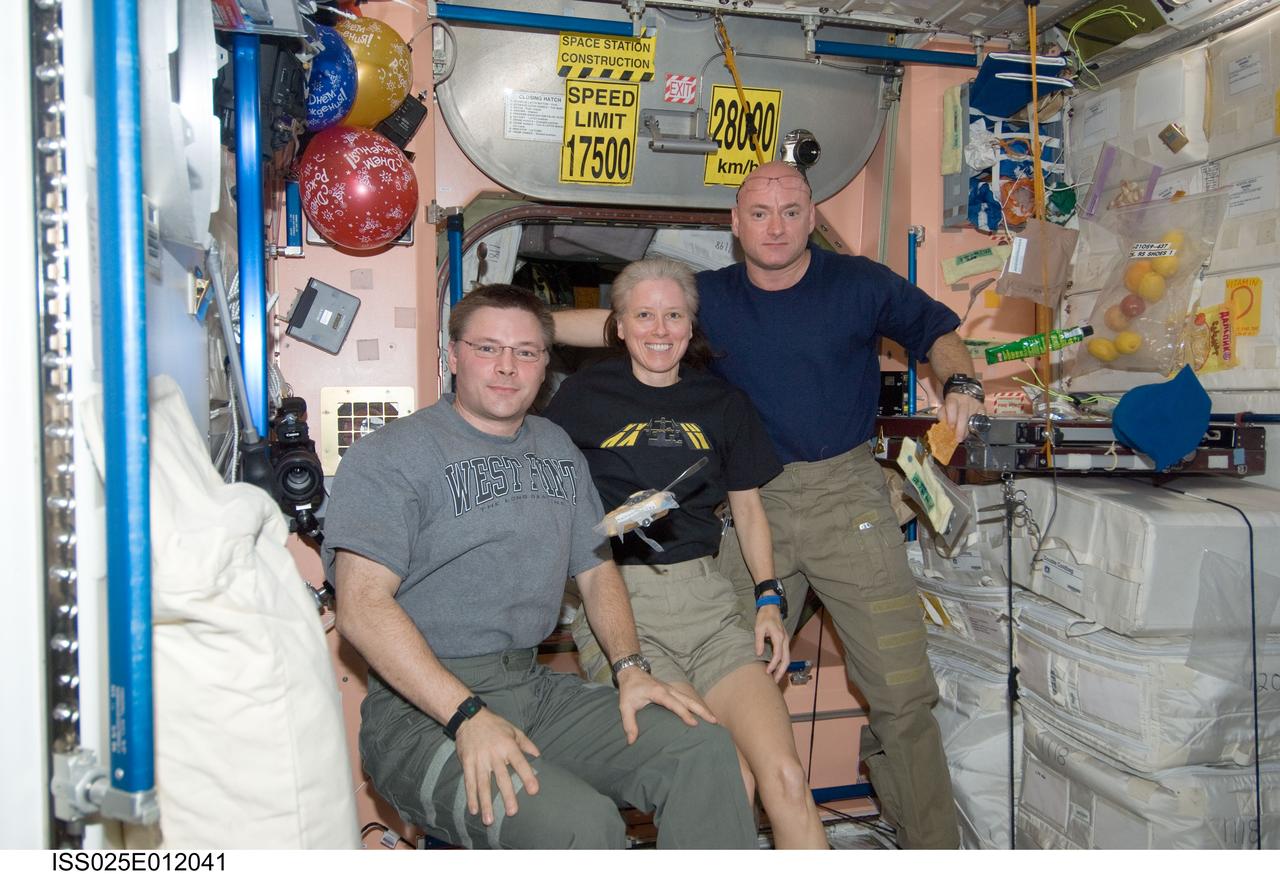 ISS025-E-012041 (7 Nov. 2010) --- NASA astronaut Doug Wheelock (left), Expedition 25 commander; along with NASA astronauts Shannon Walker and Scott Kelly, both flight engineers, pose for a photo in the Unity node of the International Space Station.