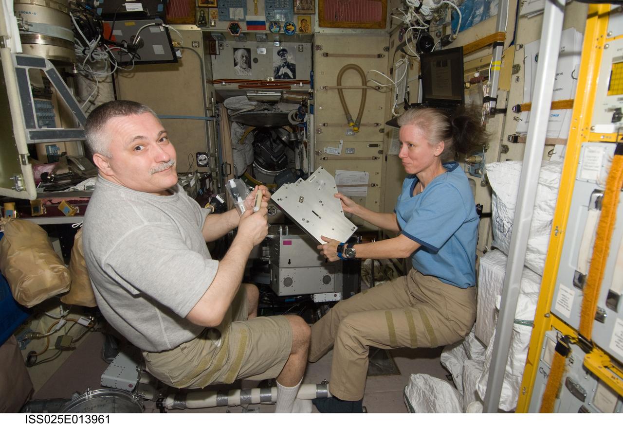 ISS025-E-013961 (10 Nov. 2010) --- Russian cosmonaut Fyodor Yurchikhin and NASA astronaut Shannon Walker, both Expedition 25 flight engineers, work in the Zvezda Service Module of the International Space Station.