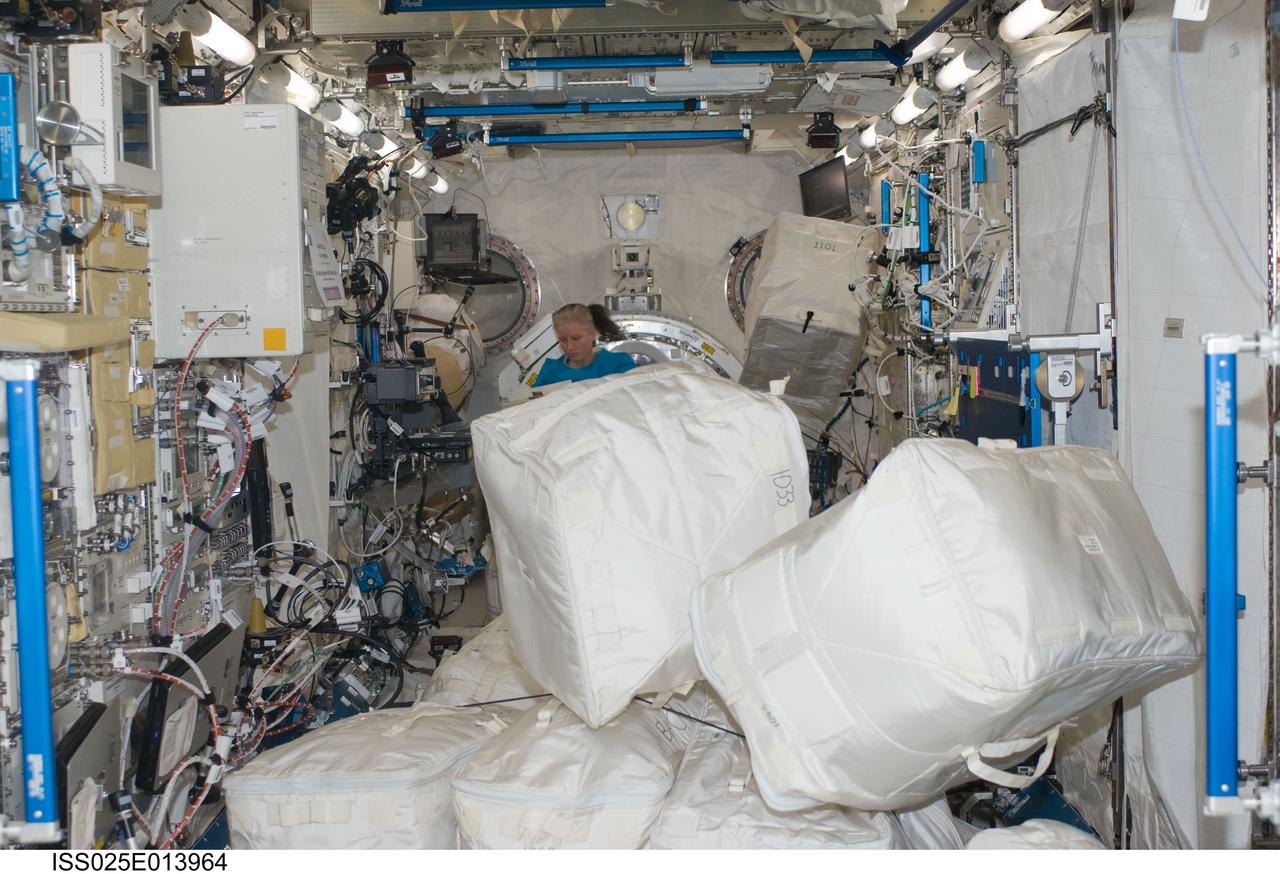 ISS025-E-013964 (11 Nov. 2010) --- NASA astronaut Shannon Walker, Expedition 25 flight engineer, works among stowage containers in the Kibo laboratory of the International Space Station.