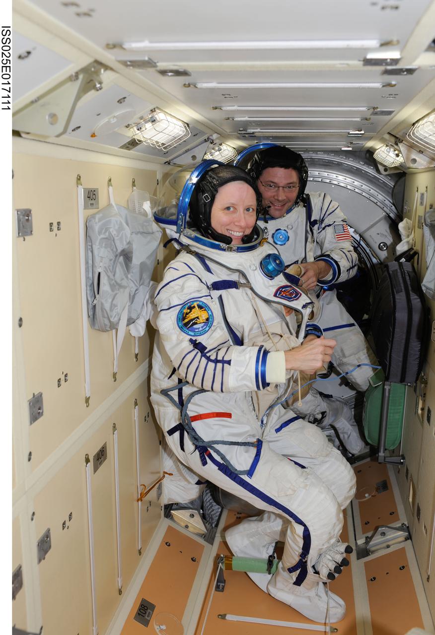 ISS025-E-017111 (22 Nov. 2010)--- NASA astronauts Shannon Walker, Expedition 25 flight engineer, and  Doug Wheelock, Expedition 25 commander;  have donned their Sokol (Russian word for 'Falcon') pressure suits and are pictured in the Russian MRM-1 module aboard the Earth-orbiting International Space Station. They, along with Russian cosmonaut Fyodor Yurchikhin, flight engineer, ingressed the docked Soyuz capsule to conduct pressurization and leak checks on their suits.
