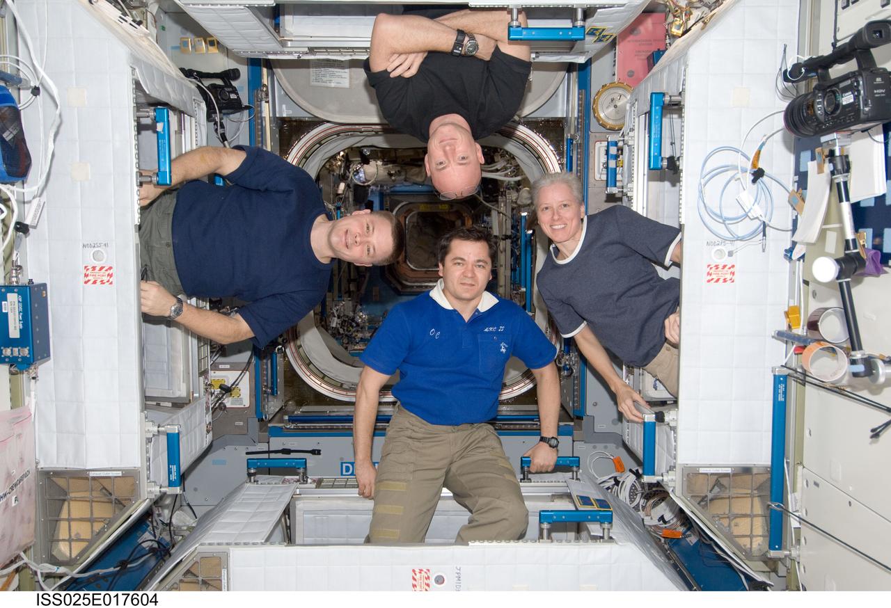 ISS025-E-017604 (25 Nov. 2010) ---  Expedition 25 crew members pose for a photo, each one floating in the entrance to their crew quarters in Node 2. Starting at the top is NASA astronaut Scott Kelly, Expedition 25 flight engineer. On the right is NASA astronaut Shannon Walker,Expedition 24/25 flight engineer. At the bottom is Russian cosmonaut Oleg Skripochka, Expedition 25/26 flight engineer, and on the left is NASA astronaut Douglas H. Wheelock, Expedition 25 commander.