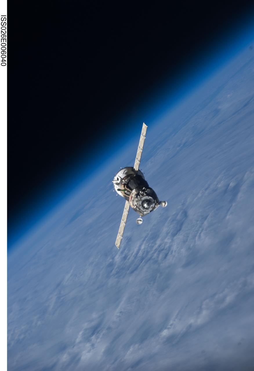 ISS026-E-006040 (25 Nov. 2010) --- The Soyuz TMA-19 spacecraft departs the International Space Station on Nov. 25, 2010. Onboard are three members of Expedition 25 – NASA astronaut Doug Wheelock, commander; along with NASA astronaut Shannon Walker and Russian cosmonaut Fyodor Yurchikhin, both flight engineers. Yurchikhin, the Soyuz commander, was at the controls of the spacecraft as it undocked at 8:23 p.m. (EST) from the station's Rassvet module. The blackness of space and Earth’s horizon provide the backdrop for the scene.