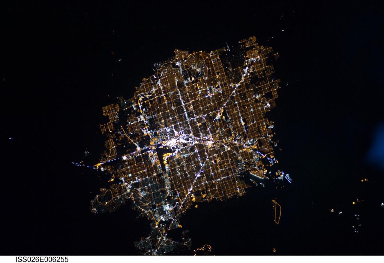 ISS026-E-006255 (30 Nov. 2010) --- This night time image, photographed by an Expedition 26 crew member on the International Space Station, features the Las Vegas, Nevada metropolitan area, located near the southern tip of the state within the Mohave Desert of the southwestern USA. While the city of Las Vegas proper is famous for its casinos and resort hotels – the city bills itself as “the entertainment capital of the world” – the metropolitan area includes several other incorporated cities and unincorporated (not part of a state-recognized municipality) areas. Crew members onboard the ISS observe and photograph numerous metropolitan sites when the areas are illuminated by sunlight, but the extent and pattern of these areas are perhaps best revealed by the city lights at night. The surrounding dark desert presents a stark contrast to the brightly lit, regular street grid of the developed metropolitan area. The Vegas Strip (center) is reputed to be the brightest spot on Earth due to the concentration of lights associated with its hotels and casinos. The tarmac of McCarran International Airport to the south is a dark feature by comparison. The airstrips of Nellis Air Force Base on the northeastern fringe of the metropolitan area are likewise dark compared to the well-lit adjacent streets and neighborhoods. The dark mass of Frenchman Mountain borders the metropolitan area to the east. Acquisition of focused night time images such as this one requires space station crew members to track the target with the handheld camera while the ISS is moving at a speed of more than seven kilometers per second (15,659 miles per hour) relative to Earth’s surface. This was achieved during ISS Expedition Six using a homemade tracking device, but subsequent crews have needed to develop manual tracking skills. These skills, together with advances in digital camera technology, have enabled recent ISS crews to acquire striking night time images of Earth.