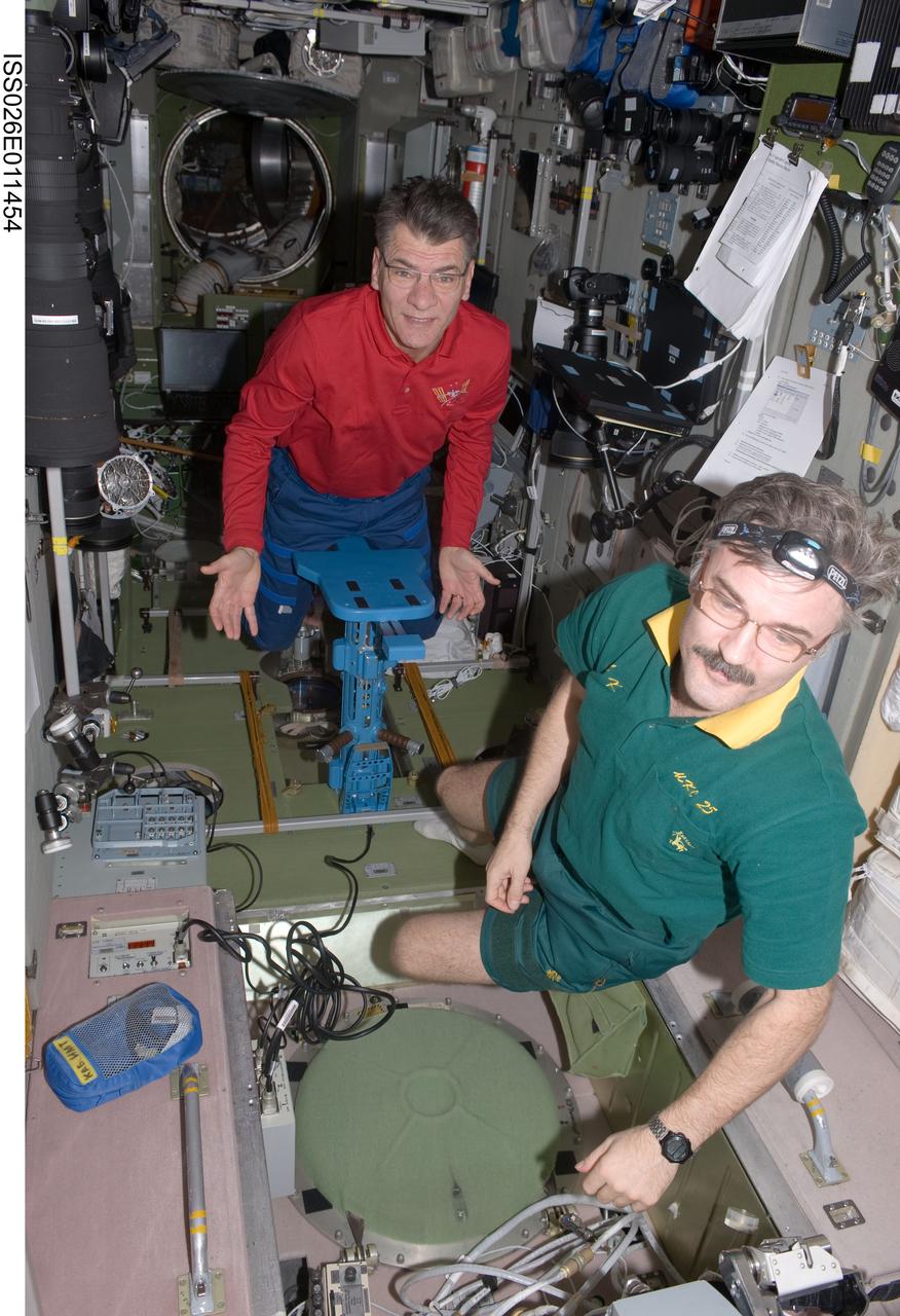 ISS026-E-011454 (22 Dec. 2010) --- European Space Agency astronaut Paolo Nespoli (background) and Russian cosmonaut Alexander Kaleri, both Expedition 26 flight engineers, are pictured in the Zvezda Service Module of the International Space Station.