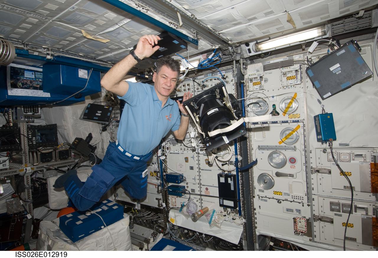 ISS026-E-012919 (20 Dec. 2010) --- European Space Agency astronaut Paolo Nespoli, Expedition 26 flight engineer,  moves the Neurospat hardware (including light shield and frame) used for the Bodies in the Space Environment (BISE) experiment, in the Columbus Module aboard the International Space Station.