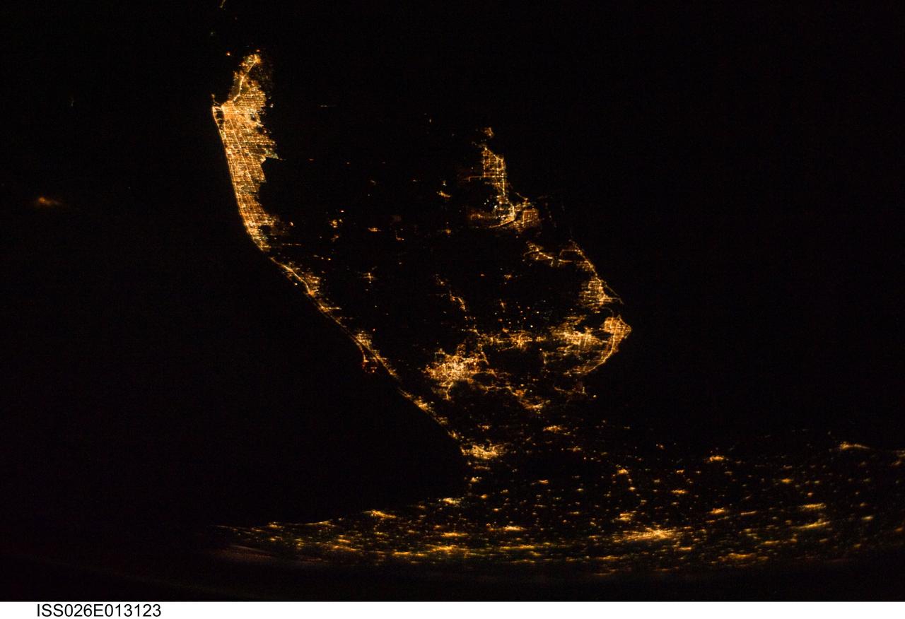 ISS026-E-013123 (28 Dec. 2010) --- A southerly looking night view of the upper two thirds of the Florida peninsula was recorded by one of the Expedition 26 crew members aboard the International Space Station on Dec. 28, 2010. Cape Canaveral and the Kennedy Space Center are very well lighted on the left (Atlantic Ocean) side of the peninsula. The Tampa-St. Petersburg area is seen on the Gulf of Mexico or right side of the frame. At bottom or in the north areas of the picture are portions of the state?s panhandle as well as cities and communities in southern Georgia.