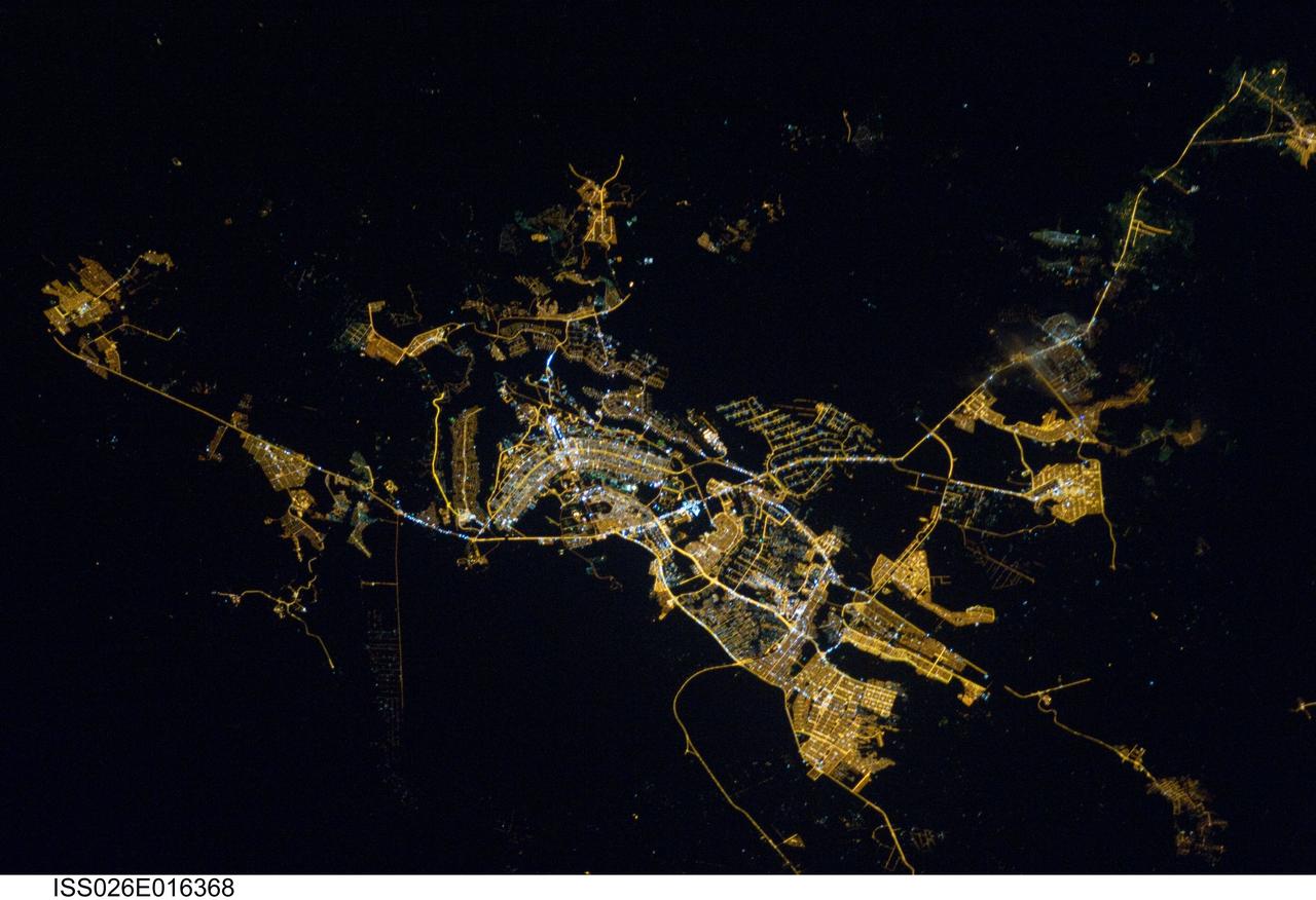 ISS026-E-016368 (8 Jan. 2011) --- Brasilia, Brazil at night time is featured in this image photographed by an Expedition 26 crew member on the International Space Station. Whether seen at night or during the day, the capital city of Brazil is unmistakable from orbit. Brasilia is located on a plateau (the Planalto Central) in the west-central part of the country, and is widely considered to be one of the best examples of 20th century urban planning in the world. One of its most distinctive design features—as seen from above—suggests a bird, butterfly, or airplane traveling along a northwest-southeast direction, and is made dramatically visible by city light patterns (center left, directly to the west of Lake Paranoa). Following the establishment of Brasilia in the early 1960s informal settlements began to form around the original planned city. Ceilandia, located to the west of Brasilia, was one such informal settlement. In 1970 the settlement was formalized by the government and is now a satellite city of Brasilia with its own distinct urban identity. The developed areas of Brasilia and its satellite cities are clearly outlined by street grid and highway light patterns at night in this photograph taken from the space station. The large unlit region to the northwest of the city is the Brasilia National Park (lower left); other dark regions to the south and southwest contain agricultural fields and expanses of Cerrado tropical savanna.