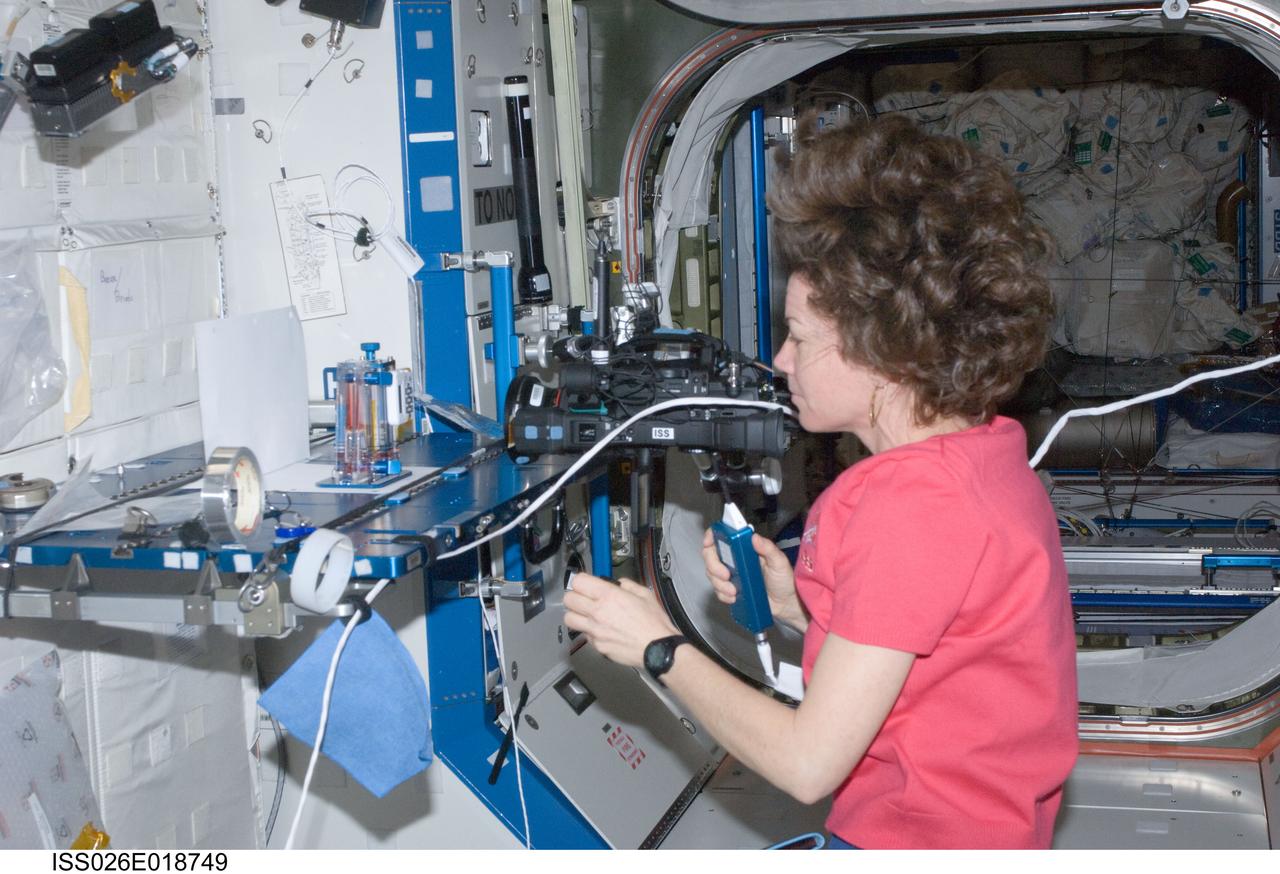 ISS026-E-018749 (18 Jan. 2011) --- NASA astronaut Catherine (Cady) Coleman, Expedition 26 flight engineer, performs a Capillary Flow Experiment (CFE) Interior Corner Flow 2 (ICF-2) test. The CFE is positioned on a Maintenance Work Area in the Destiny laboratory of the International Space Station. CFE observes the flow of fluid, in particular capillary phenomena, in microgravity.