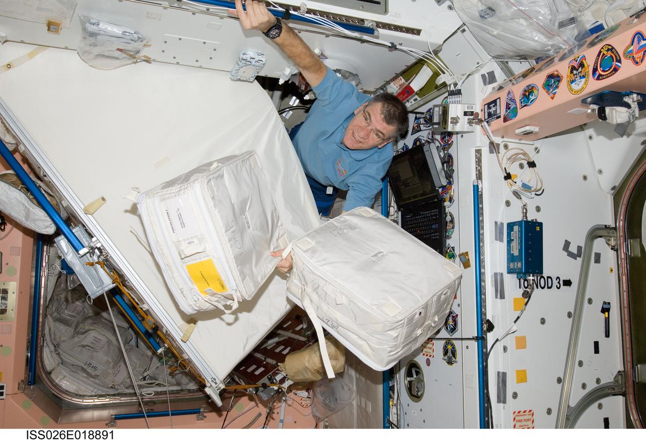 ISS026-E-018891 (20 Jan. 2011) --- European Space Agency astronaut Paolo Nespoli, Expedition 26 flight engineer, moves cargo items in the Unity node of the International Space Station.