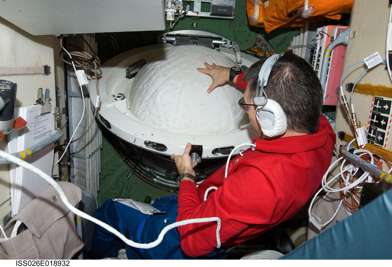 ISS026-E-018932 (21 Jan. 2011) --- While wearing a communication system headset, European Space Agency astronaut Paolo Nespoli, Expedition 26 flight engineer, closes a hatch in the Zarya Functional Cargo Block (FGB) of the International Space Station.
