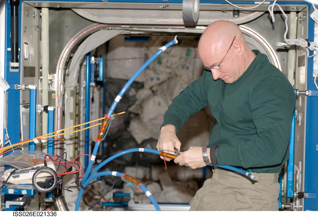 ISS026-E-021336 (13 Jan. 2011) --- NASA astronaut Scott Kelly, Expedition 26 commander, works with cables at the Maintenance Work Area in the Destiny laboratory of the International Space Station.