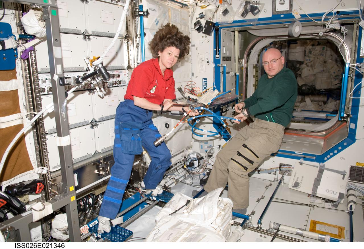 ISS026-E-021346 (13 Jan. 2011) --- NASA astronauts Scott Kelly, Expedition 26 commander; and Catherine (Cady) Coleman, flight engineer, work with cables at the Maintenance Work Area in the Destiny laboratory of the International Space Station.