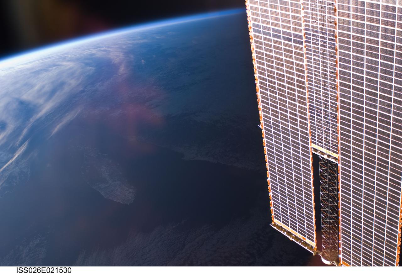 ISS026-E-021530 (1 Jan. 2011) --- Backdropped by Earth’s horizon and the blackness of space, International Space Station solar array panels are featured in this image photographed by an Expedition 26 crew member aboard the station.