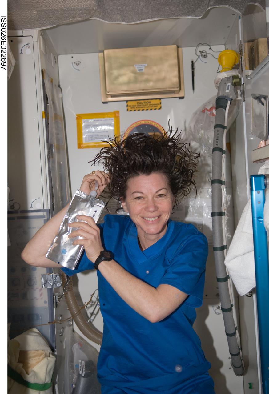 ISS026-E-022697 (31 Dec. 2010) --- NASA astronaut Catherine (Cady) Coleman, Expedition 26 flight engineer, washes her hair while aboard the International Space Station.