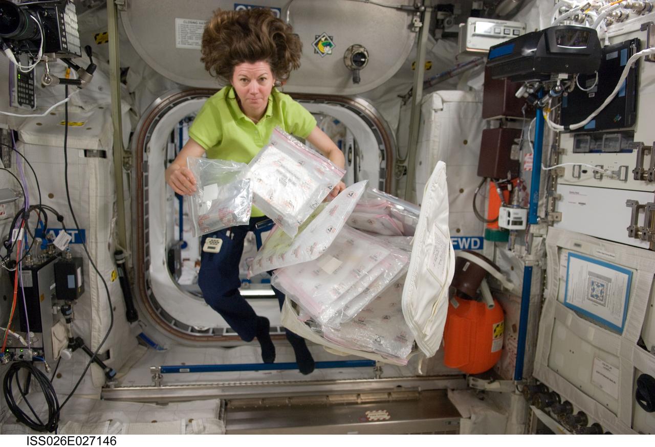 ISS026-E-027146 (16 Feb. 2011) --- NASA astronaut Catherine (Cady) Coleman, Expedition 26 flight engineer, is pictured with plastic stowage containers while floating freely in the Columbus laboratory of the International Space Station.