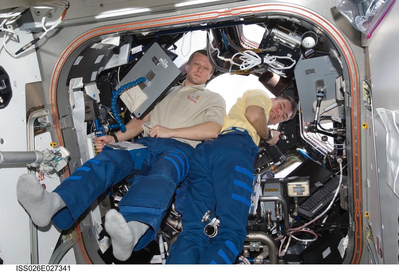 ISS026-E-027341 (16 Feb. 2011) --- Russian cosmonaut Dmitry Kondratyev (left) and European Space Agency astronaut Paolo Nespoli, both Expedition 26 flight engineers, work in the Cupola of the International Space Station.