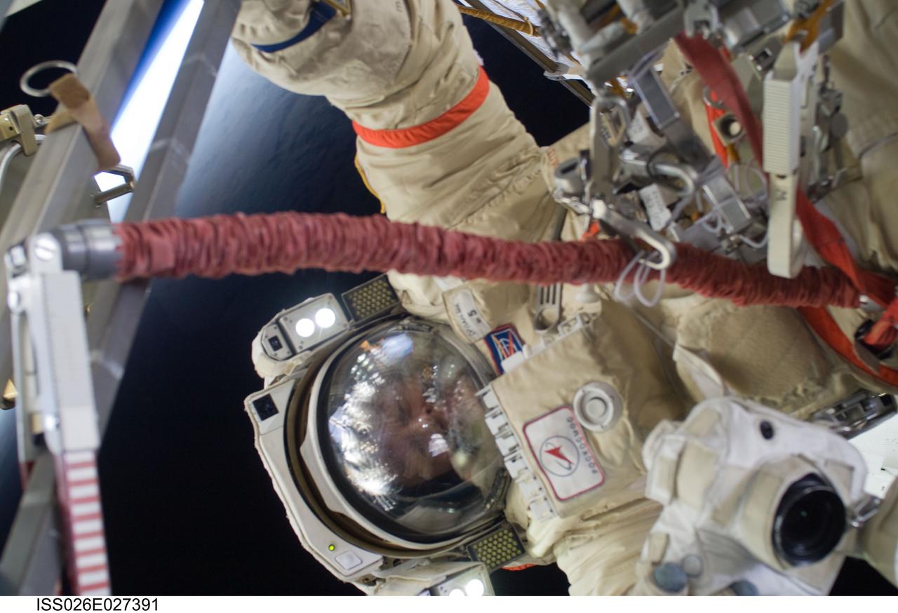 ISS026-E-027391 (16 Feb. 2011) --- Russian cosmonaut Dmitry Kondratyev, Expedition 26 flight engineer, wearing a Russian Orlan-MK spacesuit, participates in a session of extravehicular activity (EVA) focused on the installation of two scientific experiments outside the Zvezda Service Module of the International Space Station. During the four-hour, 51-minute spacewalk, Kondratyev and Russian cosmonaut Oleg Skripochka (out of frame), flight engineer, installed a pair of earthquake and lightning sensing experiments and retrieved a pair of spacecraft material evaluation panels.