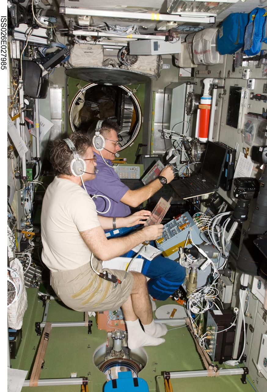 ISS026-E-027985 (21 Feb. 2011) --- Russian cosmonaut Alexander Kaleri (foreground) and European Space Agency astronaut Paolo Nespoli, both Expedition 26 flight engineers, conduct an ATV approach and docking onboard training (OBT) run in the Zvezda Service Module of the International Space Station.